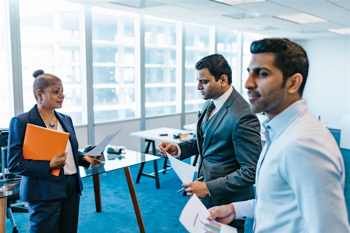 Indian executives reviewing deal documents in a bright high-rise office