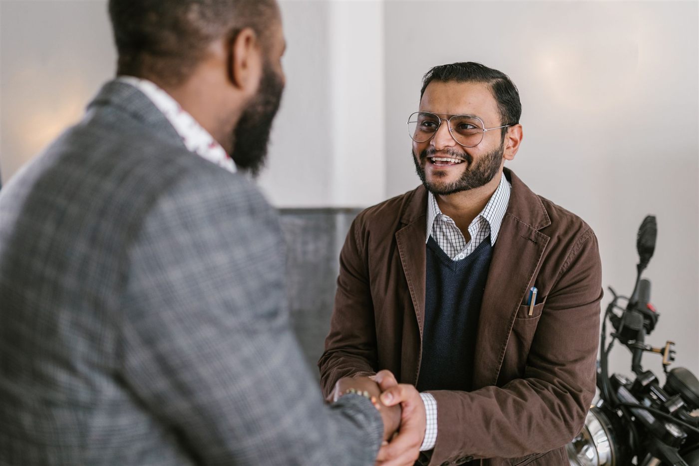 Two Indian executives smiling as they shake hands